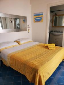 Un dormitorio con una cama grande con una manta amarilla. en Agata Suite, en Isquia