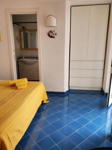 - une chambre dotée de carrelage bleu et d'un lit dans l'établissement Agata Suite, à Ischia