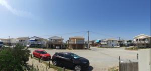 two cars parked in a parking lot in front of houses at chalet typique 50 m de la mer in Gruissan