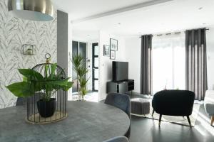 ブロッツハイムにあるLa Villetta G Blotzheim - Appartement de Standingのテーブルと椅子とテレビのあるリビングルーム
