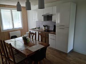 a kitchen with a wooden table and a white refrigerator at Gîte l'instant T in Thorigny
