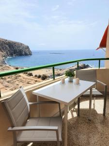 Biały stół i krzesła na balkonie z widokiem na ocean w obiekcie Vistamar Blue w Aronie