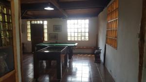 a room with a pool table and some windows at Gran Camping Cabanas da Fazenda in Visconde De Maua