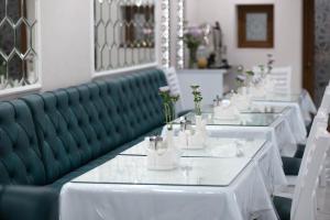 a row of tables in a restaurant with white tables at Registon Saroy Hotel in Samarkand