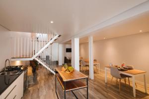 a kitchen and living room with a table and a staircase at CITY STONE HOUSE in Ponta Delgada