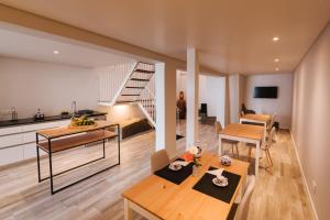 a living room with a dining table and a staircase at CITY STONE HOUSE in Ponta Delgada
