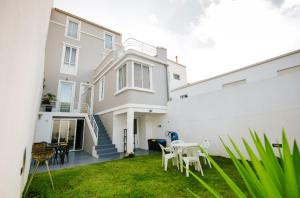 a white house with a table and chairs in the yard at CITY STONE HOUSE in Ponta Delgada