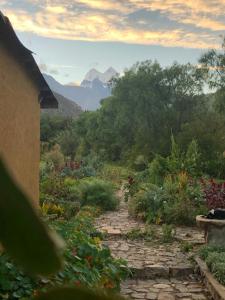 a stone path in a garden with mountains in the background at IntiRumi Inn in Caraz