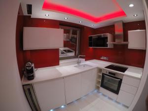 una cucina con armadi bianchi e soffitto rosso di Perfect Central London Base a Londra