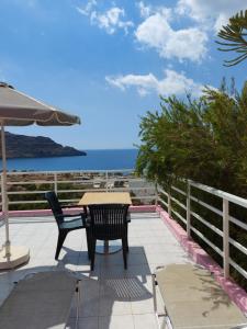 a patio with a table and chairs and the ocean at Camelia in Plakias