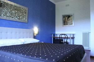罗马马志尼住宿旅馆的卧室里有一张床，墙壁是蓝色的