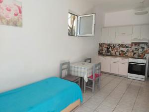 a kitchen with a table and a blue bed in it at Camelia in Plakias