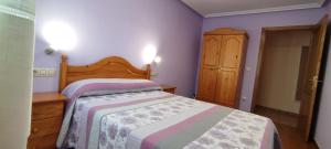 1 dormitorio con 1 cama y armario de madera en Apartamentos Casa Alvarina - Luarca, en Cortina