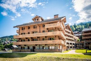 a large wooden building with wooden balconies on it at Résidence Pierre & Vacances Premium L'Hévana in Méribel