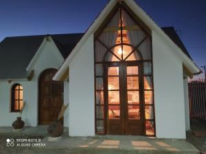 a white house with a large glass door at Hotel Nido del Flamenco in Uyuni