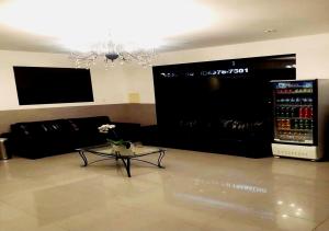 sala de estar con sofá negro y mesa en David Plaza Hotel en Osasco