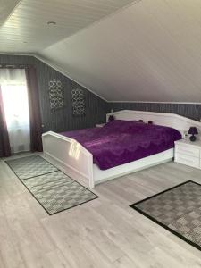 a bedroom with a bed with a purple comforter at Modern mitten in der Stadt und doch sehr ruhig in Bad Ems
