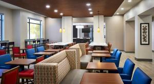 a dining room with tables and blue chairs at Holiday Inn Express Niagara-On-The-Lake by IHG in Niagara-on-the-Lake