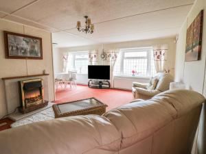 a living room with a couch and a fireplace at The Lodge in Attleborough