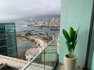 a balcony with a view of the ocean and a city at Puerto Nuevo - cerca Mall Plaza, Antofagasta in Antofagasta