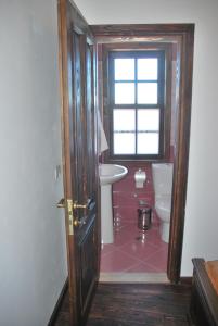 a bathroom with a toilet and a sink and a window at Hotel Klea in Berat