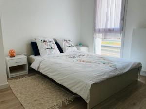 - un lit avec des draps et des oreillers blancs dans une chambre dans l'établissement Appartement Muse proche Gare, à Metz