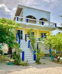 een wit en blauw huis met een blauwe trap bij JAGUAR MORNING STAR in Caye Caulker