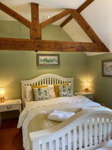 a white bed in a room with wooden beams at Idyllic Suite at Lower Fields Farm in Napton on the Hill