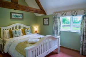 a white crib in a bedroom with a window at Idyllic Suite at Lower Fields Farm in Napton on the Hill