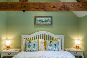 a bedroom with a white bed with two night stands at Idyllic Suite at Lower Fields Farm in Napton on the Hill