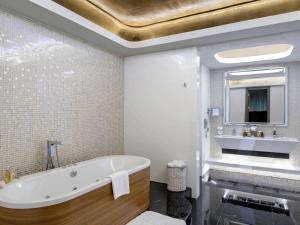 a bathroom with a tub and a sink at Rixos Premium Belek - The Land of Legends Access in Belek