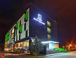 a building with a sign on it at night at Hotel Cubix in Braşov