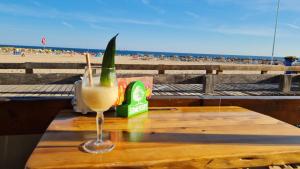 a drink sitting on a wooden table at the beach at Acropole Algarve Beach Apartment in Portimão