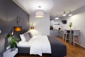 a bedroom with a large bed and a kitchen at Gertrudy Old Town Apartments in Kraków