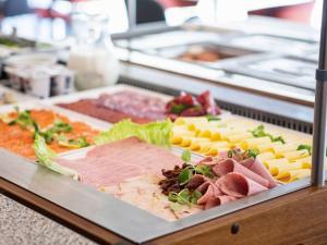 a display case with different types of meats and cheese at IBIS Styles Kaunas Centre in Kaunas