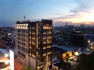 un edificio iluminado en una ciudad por la noche en Mercure Surabaya Manyar en Surabaya