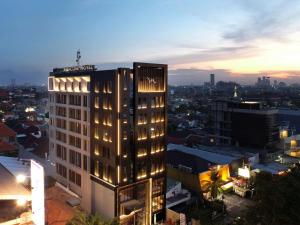 a lit up building in a city at night at Mercure Surabaya Manyar in Surabaya