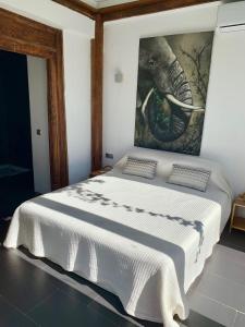 Ibiza style house,6 pers, luxury,with private pool في سان خوسيه دي سا أتاليا: غرفة نوم بسرير ابيض مع لوحة على الحائط