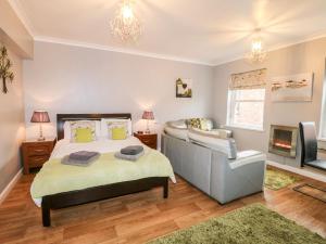 a bedroom with a bed and a couch and a tv at Grayz Studio in Lincoln