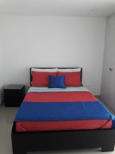 a bed with blue and red pillows in a room at Seway Morros Cartagena in Cartagena de Indias