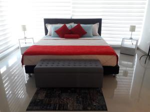 卡塔赫納的住宿－Seway Morros Cartagena，一间卧室配有一张带红色枕头的大床