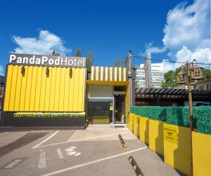 ein gelbes Gebäude mit einem Schild darüber in der Unterkunft Panda Pod Hotel in Richmond