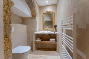 a bathroom with a sink and a toilet and a mirror at La Maison de Beaumont in Beaumont-de-Pertuis