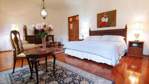 a bedroom with a bed and a table and a chair at Casa Montalvo Bed & Breakfast in Cuenca