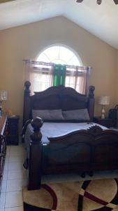 sypialnia z dużym łóżkiem i oknem w obiekcie Luxurious Secret Escape w mieście Portmore