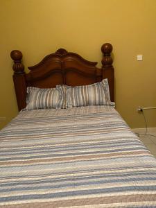 łóżko z kołdrą w paskach w sypialni w obiekcie Luxurious Secret Escape w mieście Portmore