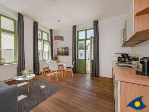 Villa Frohsinn Whg 12 في بانسين: مطبخ وغرفة معيشة مع طاولة