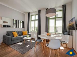 Villa Frohsinn Whg 12 في بانسين: غرفة معيشة مع أريكة وطاولة وكراسي