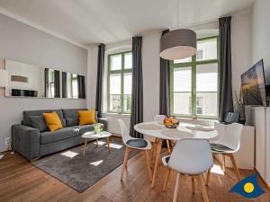 a living room with a couch and a table and chairs at Villa Frohsinn Whg 12 in Bansin