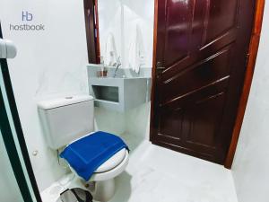 uma casa de banho com um WC e um banco azul em Casa próxima a praia do pecado - WIFI 200MB - TV Smart - 2 Quartos - Cozinha equipada - Churrasqueira - Pet friendly - Quintal em Macaé